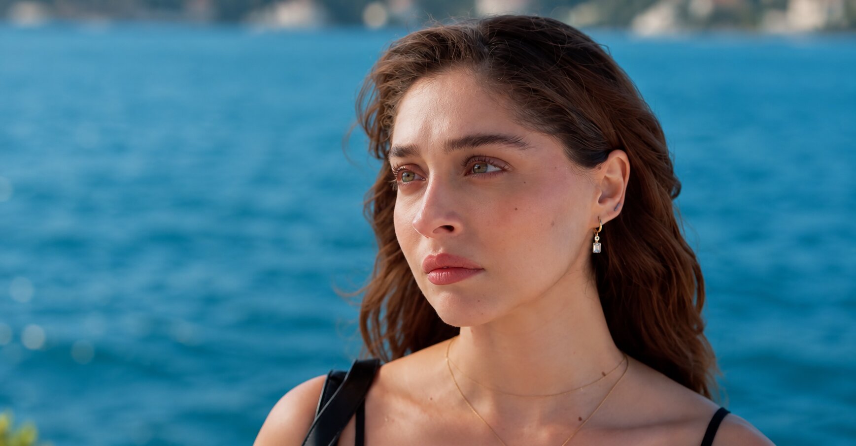 Emotional close-up of Cemre Baysel as Zeynep Candan with the sea in the background in Sins and Roses Season 2 (Güller ve Günahlar).