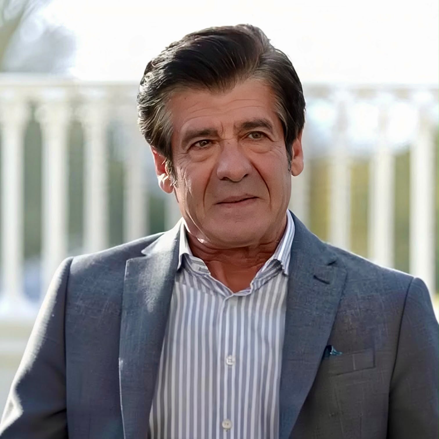 İştar Gökseven as Yusuf Tecer looking thoughtful in a suit in Sins and Roses Season 2 (Güller ve Günahlar / Woroud Wa Thonoub).