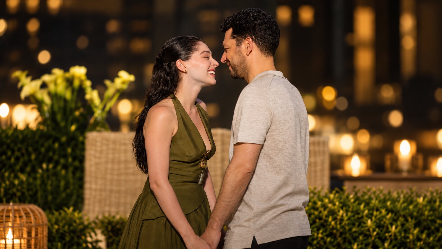 Murat Yıldırım as Serhat Tecer and Cemre Baysel as Zeynep Candan laughing happily while facing each other in a garden at night in Sins and Roses Season 2 (Güller ve Günahlar / Woroud Wa Thonoub).